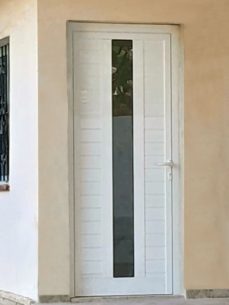 Puerta de calle con tablillas de aluminio y vidrio.